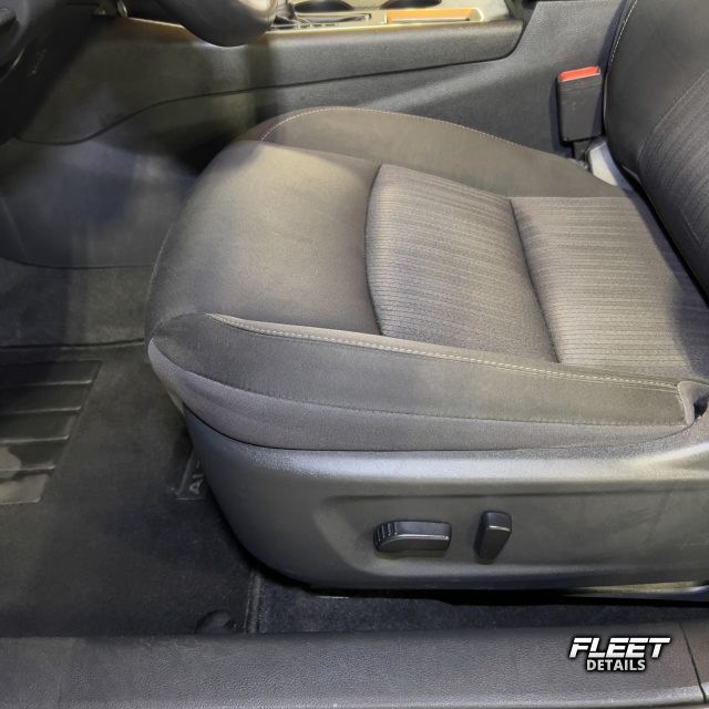 Inside of a vehicle's interior showing the dashboard and seats and carpet cleaned from an interior mobile detail